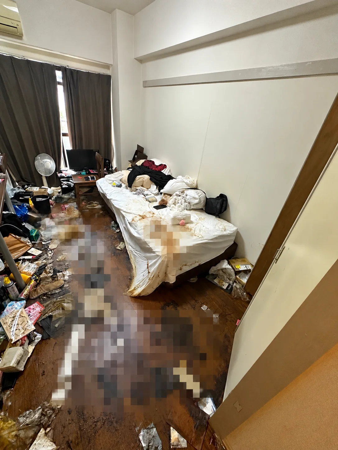 名古屋市西区の特殊清掃、作業前の室内に残置物と床の汚れが確認できる様子（一部モザイク処理）
